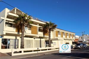 een gebouw met palmbomen en een bord ervoor bij Aeromar Beach Hotel in Faro
