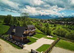 an aerial view of a house with mountains in the background at Domki Sarnówka in Czarna Góra