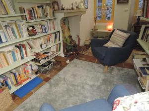 una sala de estar llena de estanterías llenas de libros en La Maison Bleue en Sault-de-Vaucluse