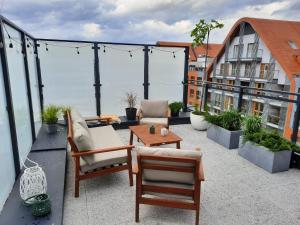 a patio with chairs and a table on a balcony at Trident Apartment III in Gdańsk