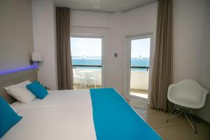 1 dormitorio con cama y vistas al océano en Les Palmiers Beach Boutique Hotel & Luxury Apartments, en Lárnaca