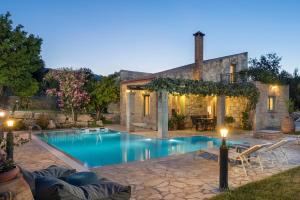 a swimming pool in a yard with a house at Boutique Villa Petra Amanda in Fílippos