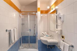 uma casa de banho com uma cabina de duche em vidro e um lavatório. em Hotel Bristol em Sorrento