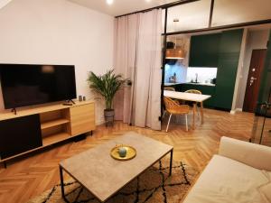 a living room with a television and a table at Trident Apartment III in Gdańsk