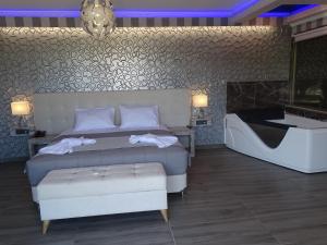 1 dormitorio con 1 cama y bañera en una habitación en Garden Palace Hotel, en Laganas