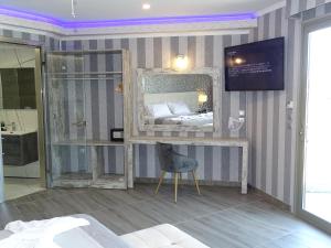 1 dormitorio con 1 cama con espejo y silla en Garden Palace Hotel, en Laganas