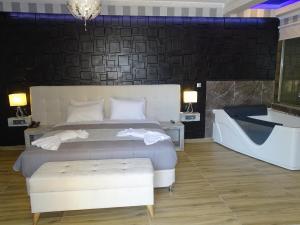 1 dormitorio con 1 cama grande y bañera en Garden Palace Hotel, en Laganas