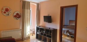 a room with a room with a bed and a television at Apartamentos La Panerona Centro in Tineo