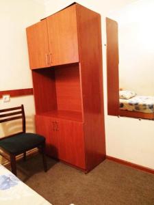 a wooden cabinet with a chair and a mirror at Hostel Sakharov & Tours in Yerevan