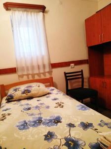 a bedroom with a bed with a blue and white blanket at Hostel Sakharov & Tours in Yerevan