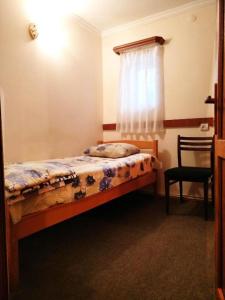 a small bedroom with a bed and a window at Hostel Sakharov & Tours in Yerevan