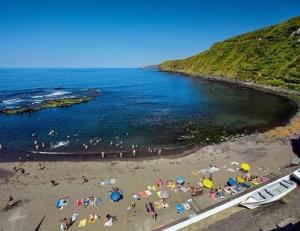 a group of people on a beach with umbrellas at Cantinho do Sonho in Maia