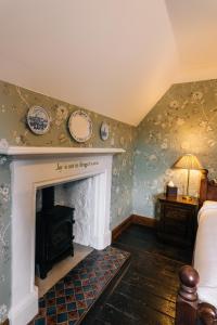 a room with a fireplace with plates on the wall at Rokeby Manor in Invergarry