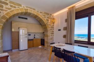 a kitchen with a stone archway and a table and chairs at Athinais villa in Palaiochora