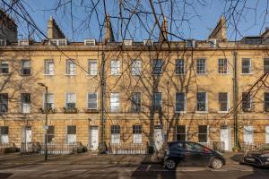 a car parked in front of a large building at Park View Two-Bedroom Apartment in Bath