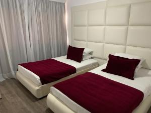 Dos camas en una habitación de hotel contigua en Pasithea Holiday Apartments en Lárnaca