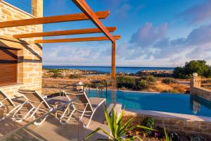 a house with a swimming pool with a view of the ocean at Athinais villa in Palaiochora