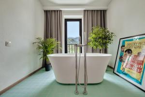 a bathroom with a large tub and a movie poster at Intourist Kazbegi in Kazbegi