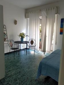 een slaapkamer met een tafel en stoelen en een bed bij A due passi dal mare appartamento con giardino in Albissola Marina