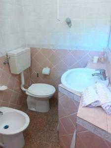 een roze badkamer met een toilet en een wastafel bij Sandilos in Sorso