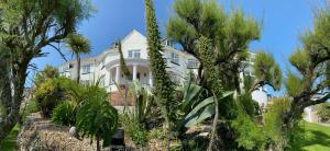 een groot wit huis met bomen ervoor bij The Whipsiderry Hotel in Newquay