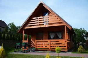 a small cabin with a grill in a yard at Słoneczna Dolina in Kąty Rybackie +10 photos