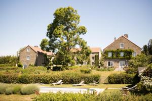 una casa grande con un patio delante en B&B La Ferme de l'Airbois, en Yvoir