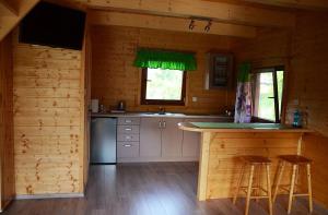 a kitchen with a counter in a wooden cabin at Słoneczna Dolina in Kąty Rybackie