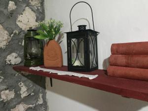 un estante con una linterna y un jarrón de flores en Etno House Stari mlin, en Konjic