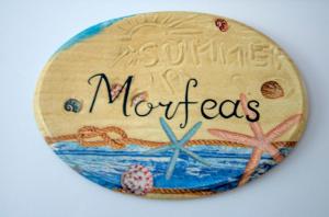 Un bottone con una foto dell'oceano e le parole miracoli di Kapetanios Luxury ad Agios Georgios