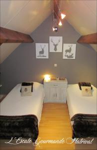 two beds in a attic room with drawings on the wall at L'Escale Gourmande in Hatrival