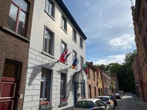 um edifício com bandeiras ao lado de uma rua em Hotel Montovani em Bruges