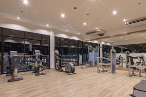 a gym with several treadmills and exercise equipment at Kata Palm Resort - SHA Plus in Kata Beach