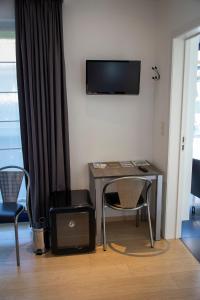 a room with a table and two chairs and a television at B&B Lievejan in Jabbeke