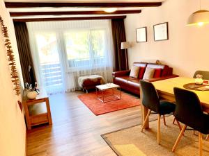 a living room with a table and a couch at Appartements Elan in Zermatt