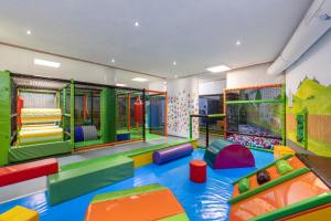 una sala de juegos para niños con tobogán y equipo de juegos en Familotel Kaiserhof - Families only, en Berwang