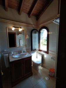 a bathroom with a sink and a toilet and a window at Villalen in Cuerres