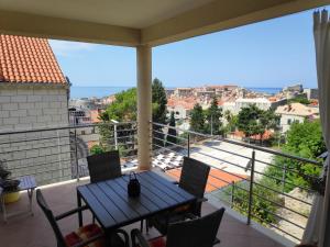 a balcony with a table and chairs and a view at Apartments Romano in Dubrovnik