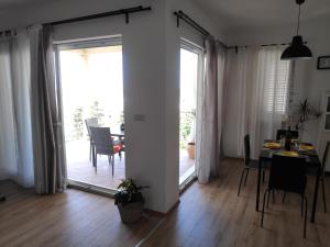 a living room with a dining table and a sliding glass door at Apartments Romano in Dubrovnik