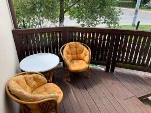 two chairs and a table on a deck at Mazury Apartament in Ostróda