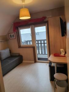 a living room with a couch and a large window at Los Reyes II - klimatyzowane pokoje in Krynica Morska