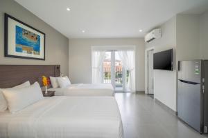 a hotel room with two beds and a television at Park Hill Hotel - Phu My Hung in Ho Chi Minh City