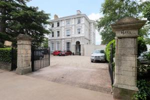 a gate to a white house with cars parked in front at Pittville Circus Road in Cheltenham