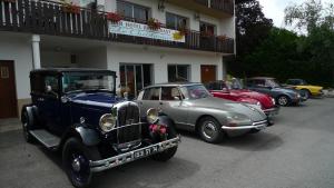 un grupo de coches viejos estacionados frente a un edificio en Hôtel Le Christania, en Bellevaux 76 fotos más