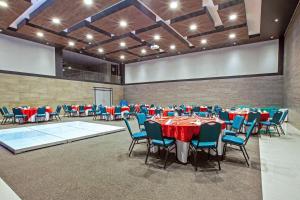 un salón de banquetes con mesas y sillas rojas y azules en Wyndham Garden Cancun Downtown, en Cancún