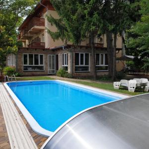 a swimming pool in front of a house at Villa Dorottya in Balatonföldvár