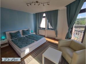 a bedroom with a bed and a living room with a couch at De Lux Gästehaus Völklingen in Völklingen