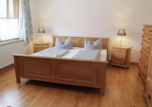 ムルナウ・アム・シュタッフェルゼーにあるSporerhofのベッドルーム1室(大型木製ベッド1台、ナイトスタンド2台付)