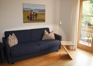 un sofá azul en una sala de estar con una pintura en Sporerhof en Murnau am Staffelsee