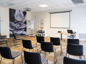 Habitación de clase con sillas y pantalla blanca en ibis Laval Le Relais D'Armor en Changé